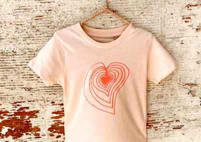 foto-camiseta-blanca-manga corta-de-talla-para-niños-con-estampación-de-corazón-rojo-en-serigrafía-artesanal-y-sostenible-bihotz